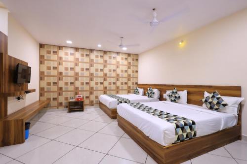 a hotel room with two beds and a flat screen tv at Maruti Group of Hotels - Shri Naman in Nāthdwāra