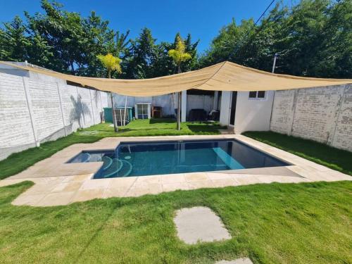 a swimming pool with a canopy in a yard at Casa Mochileros Anonimos in El Guayabo