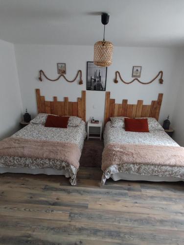 two beds sitting next to each other in a bedroom at Gîte La Petite Longère in Septfonds