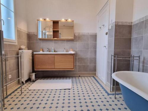 a bathroom with a sink and a tub and a mirror at Maison de meulière près de Paris avec jardin, cheminée et tout confort inclus - FR-1-527-45 in Carrières-sur-Seine
