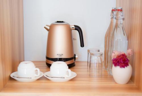 a tea kettle and cups on a wooden shelf at Chak’z 1964 Beach in Dharavandhoo