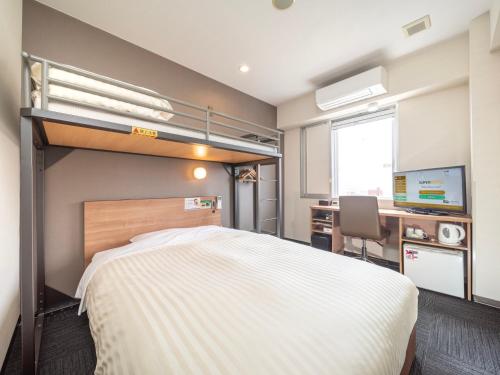 1 dormitorio con 1 cama y escritorio con ordenador en Super Hotel Yamaguchi Yuda Onsen en Yamaguchi