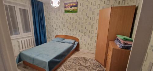 um pequeno quarto com uma cama e uma janela em Двухкомнатная квартира на юго-востоке г.Караганда em Karaganda