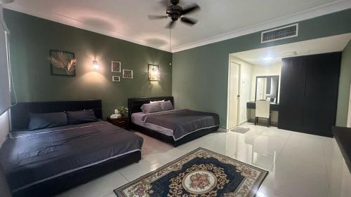 a bedroom with two beds and a ceiling fan at Desaru Homestay Southern, Tiara Desaru Seaview Residensi in Bandar Penawar