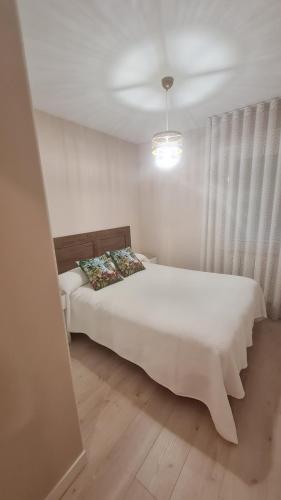1 dormitorio con 1 cama con sábanas blancas en Casillas Bulevar, en Burgos