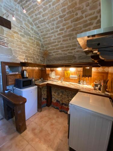 a small kitchen with a counter and a stove at Gîte de Lespinasse in Saint-Cernin