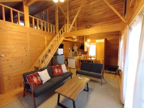 a living room with a couch and a table at ふらの田園コテージヌプリ in Nakafurano
