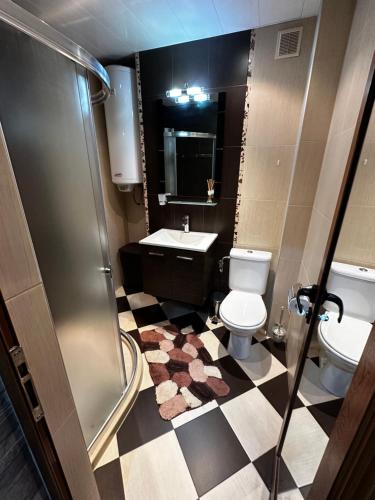 a bathroom with a toilet and a sink and a shower at KK Apartments in Stara Zagora