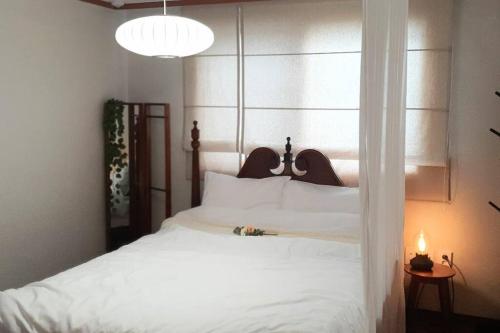 a bedroom with a large white bed with a window at Our moment #EuropeAirbnbmood#freeparking#cafebathroom#simmons#max4 in Daejeon