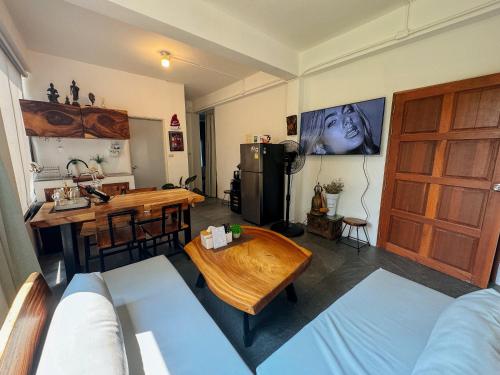 a living room with a couch and a table at Tanouy Garden in Baan Khai