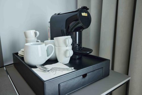 a coffee maker and cups on a table at Hotel EDELWEISS Berchtesgaden Superior in Berchtesgaden