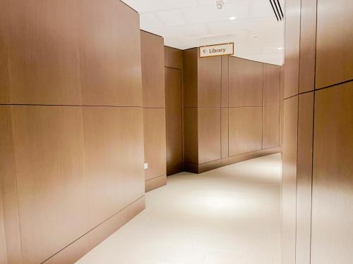 a hallway with brown walls and a sign that reads elevator at Downtown Luxury - Stunning Burj Khalifa & Sea View - 5 Minutes Walk to Dubai Mall in Dubai