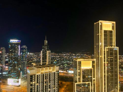 a city skyline at night with tall buildings at Downtown Luxury - Stunning Burj Khalifa & Sea View - 5 Minutes Walk to Dubai Mall in Dubai