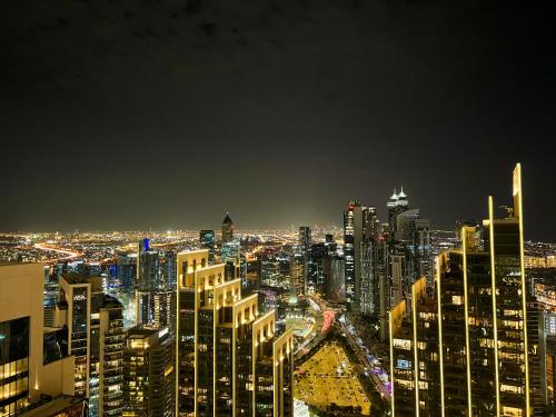 a night view of a city with tall buildings at Downtown Luxury - Stunning Burj Khalifa & Sea View - 5 Minutes Walk to Dubai Mall in Dubai