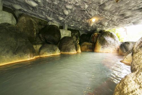a pool of water under a bridge with rocks at Okuhida Garden Hotel Yakedake in Takayama