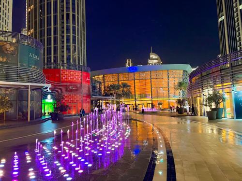 einen beleuchteten Brunnen in einer Stadt in der Nacht in der Unterkunft Downtown Luxury - Stunning Burj Khalifa & Sea View - 5 Minutes Walk to Dubai Mall in Dubai