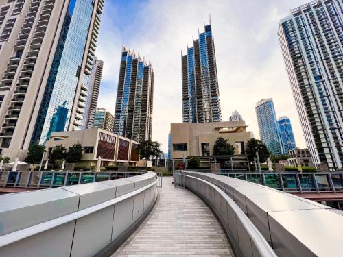 a walkway in a city with tall buildings at Downtown Luxury - Stunning Burj Khalifa & Sea View - 5 Minutes Walk to Dubai Mall in Dubai