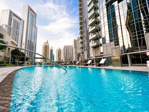 a large swimming pool in a city with tall buildings at Downtown Luxury - Stunning Burj Khalifa & Sea View - 5 Minutes Walk to Dubai Mall in Dubai