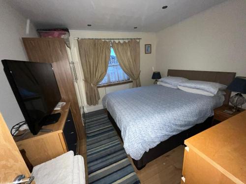 a small bedroom with a bed and a television at Broxbourne Two-Bedroom Apartment Close To Amenities in Hoddesdon