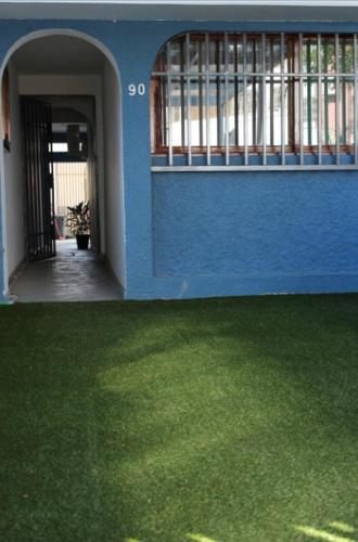 niebieski budynek z zieloną trawą przed nim w obiekcie Ka maxakeni guesthouse w mieście Maputo