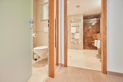 a bathroom with a toilet and a shower at Hotel EDELWEISS Berchtesgaden Superior in Berchtesgaden