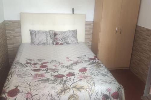 1 Schlafzimmer mit einem Bett mit Blumenbettdecke in der Unterkunft Cadete house in Albufeira