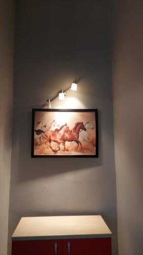 Balikesir karesi grup konaklama pansiyon في باليكسير: لوحة للخيول على جدار في الغرفة