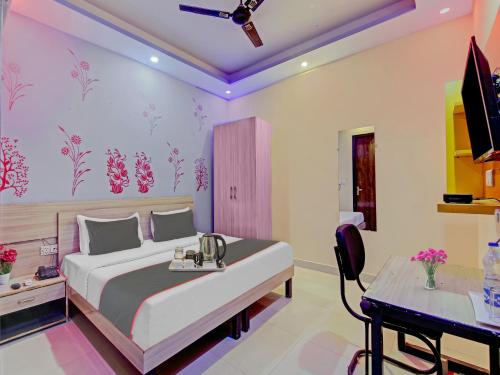 a bedroom with a large bed and a desk at Rose residency in New Delhi