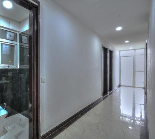 een hal met een spiegel en een witte muur bij icyhotels ncr international in Noida