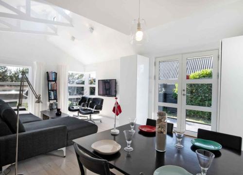a living room with a black table and chairs at Exclusive Architect Designed Beach House in Karrebæksminde