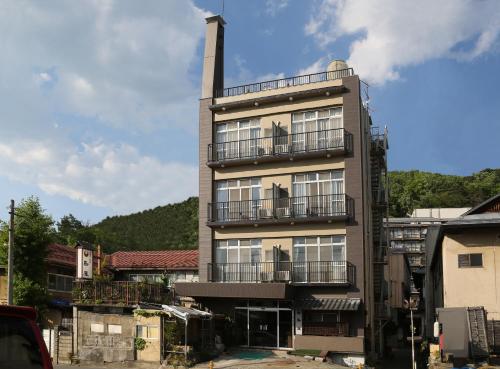 un edificio alto con una torre con balcón en Shimaya, en Yamanouchi