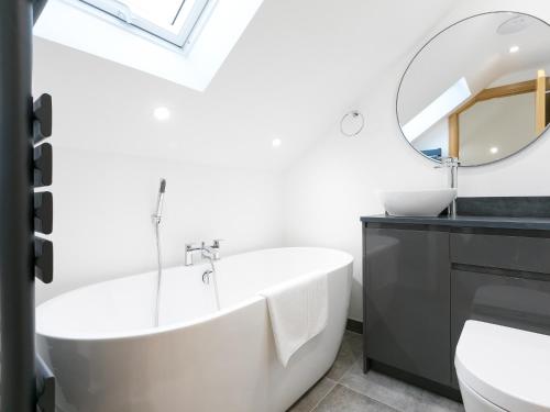 a bathroom with a white tub and a mirror at Nova Cottage in St Ives