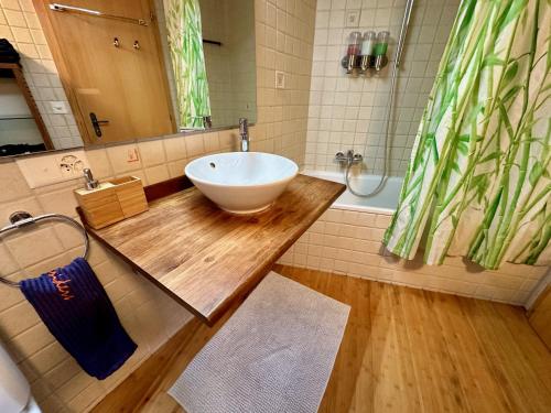 y baño con lavabo en un mostrador de madera. en Chalet typique du Valais,Maison bio et bien-être! en Chermignon-dʼen Haut