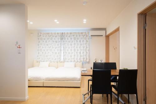 una camera con letto, tavolo e sedie di The Peak Villa Suite Hokkaido a Higashikawa