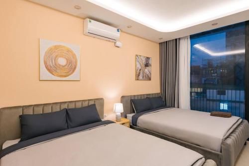 Cette chambre comprend 2 lits et une fenêtre. dans l'établissement Morden Apt/Central/2Br/City view/, à Hanoï