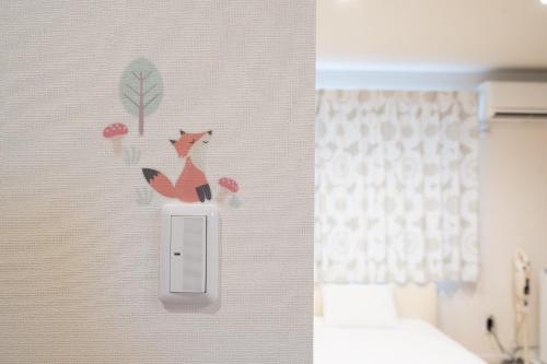 a light switch with two fox decals on a wall at The Peak Villa Suite Hokkaido in Higashikawa