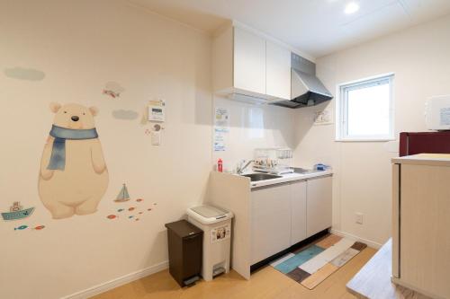 a kitchen with a teddy bear mural on the wall at The Peak Villa Suite Hokkaido in Higashikawa