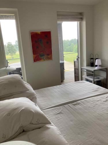 een slaapkamer met een bed en een raam met uitzicht bij Cottage Near Scandinavias Finest Golf Courses in Nimtofte