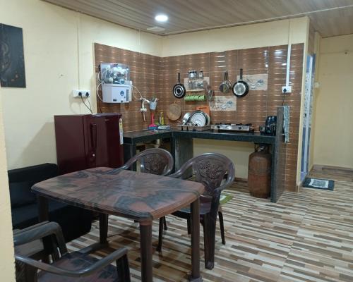 uma cozinha com mesa e cadeiras num quarto em Talpona Beach Studios em Magdāl
