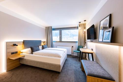 a hotel room with a bed and a tv at BOLLWERK Lifestyle Hotel, automatisiertes Hotel mit Self Check In in Immenstadt im Allgäu