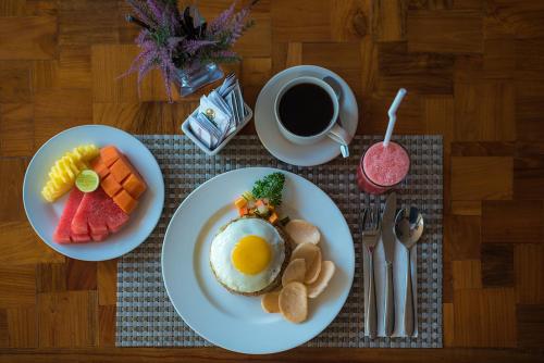 een tafel met twee borden eten en een kop koffie bij Padmasari Resort Lovina in Lovina