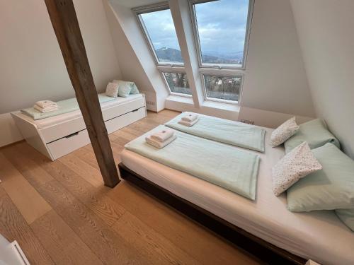 een kleine slaapkamer met een bed en 2 ramen bij Parkhotel Smržovka in Smržovka