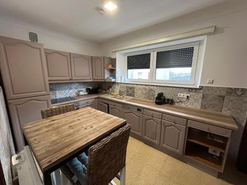 a kitchen with a wooden table and a sink at Chambre meublé à Belval in Sanem