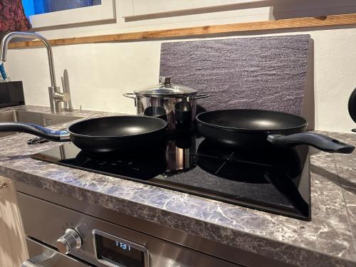 two pans sitting on top of a stove in a kitchen at Fresh & Simple near Gstaad in Gstaad