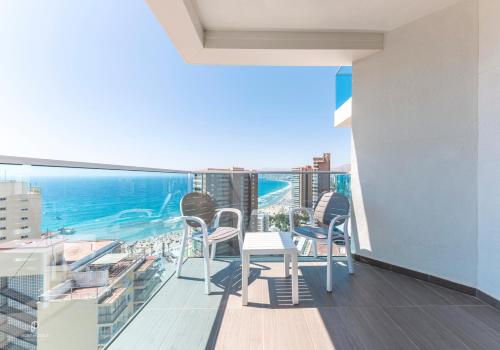 a balcony with chairs and a table and the ocean at Port Benidorm Hotel & Spa 4* Sup in Benidorm