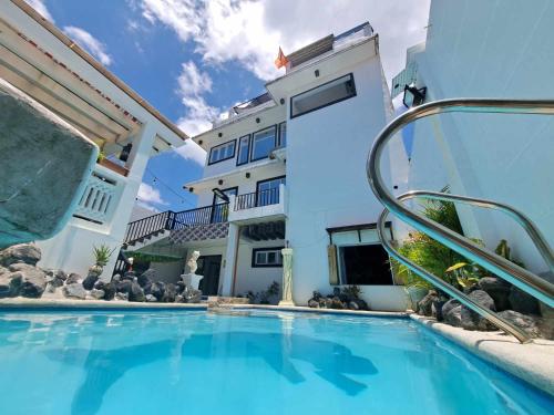 a swimming pool in front of a building at Arthur Private Resort in Legazpi