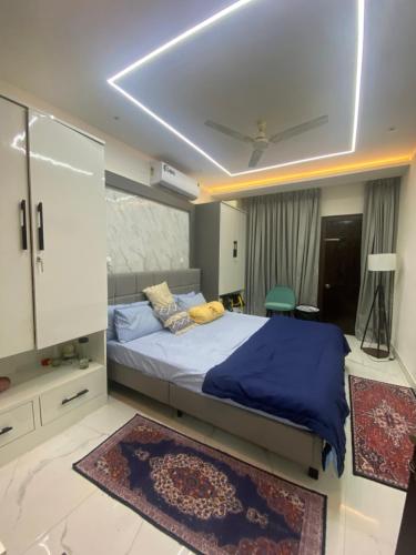 um quarto com uma cama grande e um cobertor azul em Krishna Villa em Bhubaneshwar