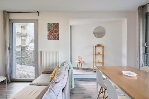un salon avec un canapé et une table dans l'établissement Appartement proche métro & 2 balcons + parking, à Lille