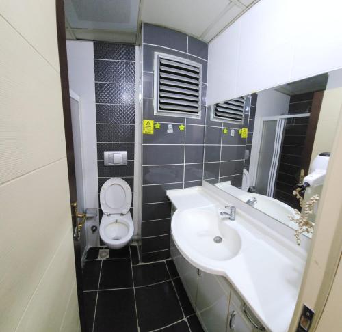 a bathroom with a sink and a toilet at Balıkesir karesi grup konaklama ve pansiyon in Balıkesir