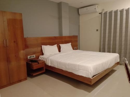 a bedroom with a large bed with a wooden headboard at RELAX INN in Guwahati